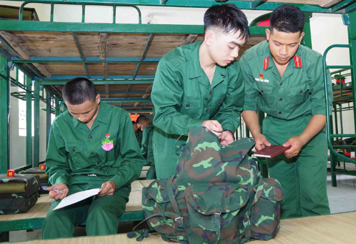  Tiểu đội trưởng hướng dẫn chiến sĩ mới sắp xếp vật chất trong ba lô. 