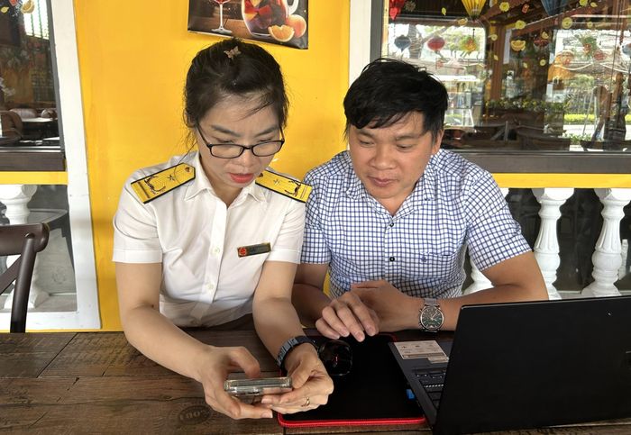 Ứng dụng thuế điện tử eTax Mobile mang lại nhiều tiện ích. TRONG ẢNH: Công chức Chi cục Thuế khu vực Sơn Trà - Ngũ Hành Sơn hướng dẫn chủ hộ kinh doanh cài đặt ứng dụng eTax Mobile. Ảnh: MAI QUẾ