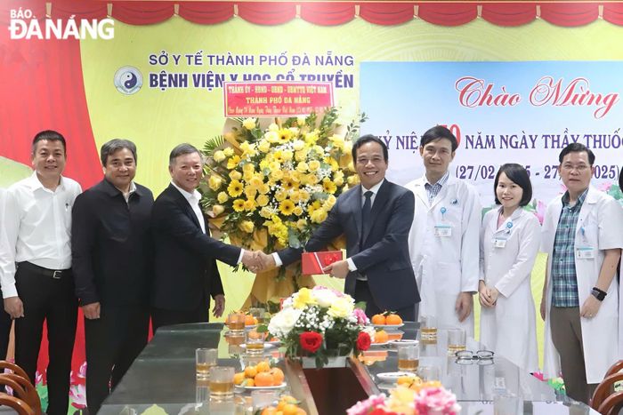 Chủ tịch Ủy ban MTTQ Việt Nam thành phố Lê Văn Trung (thứ 3, bên trái sang) tặng hoa chúc mừng Bệnh viện Y học cổ truyền Đà Nẵng. Ảnh: KHÁNH NGÂN