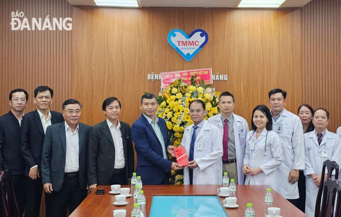 Phó Chủ tịch Thường trực UBND thành phố Hồ Kỳ Minh (thứ 5, bên trái qua) tặng hoa chúc mừng Bệnh viện Đa khoa Tâm Trí Đà Nẵng. Ảnh: L.P