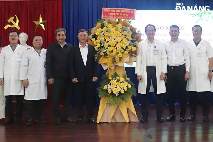 Chủ tịch Ủy ban MTTQ Việt Nam thành phố Lê Văn Trung (thứ 4, bên trái sang) tặng hoa chúc mừng Bệnh viện Phục hồi chức năng Đà Nẵng. Ảnh: KHÁNH NGÂN