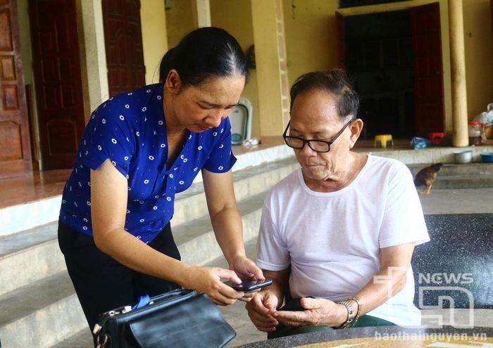Cán bộ xã Nam Hòa (Đồng Hỷ) hướng dẫn người cao tuổi sử dụng một số ứng dụng mạng xã hội trên điện thoại.