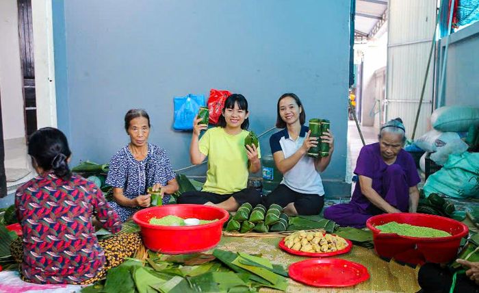 Chị Hoàng Thị Kim Cúc (thứ 2 từ phải qua) làm bánh tét mặt trăng - Ảnh: Trần Tuyền