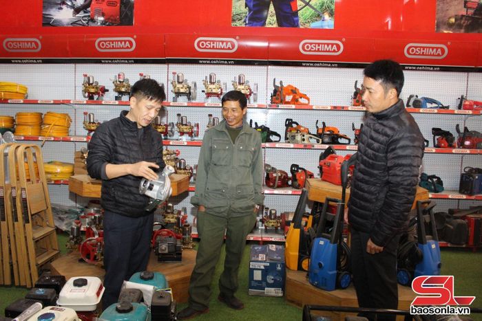 Cán bộ thị trấn Sông Mã, huyện Sông Mã (đầu tiên, bên tay phải) trao đổi với hộ kinh doanh trên địa bàn.