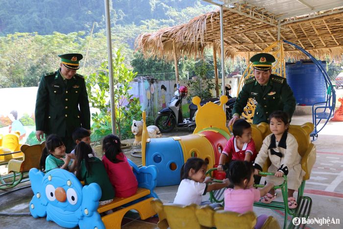 Cán bộ Đồn Biên phòng Tam Quang vui cùng các cháu điểm Trường Mầm non Tùng Hương, xã Tam Quang, huyện Tương Dương. Ảnh: Khánh Ly