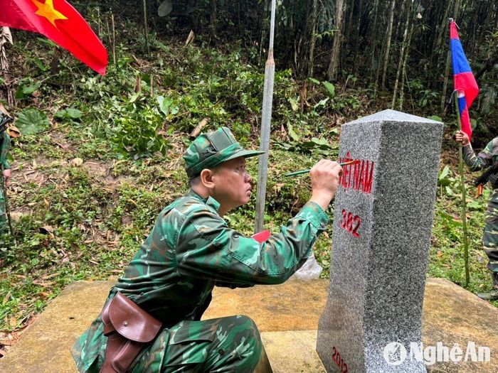 Đội trưởng tuần tra Đồn Biên phòng Nhôn Mai sơn cột mốc. Ảnh: Hải Thượng