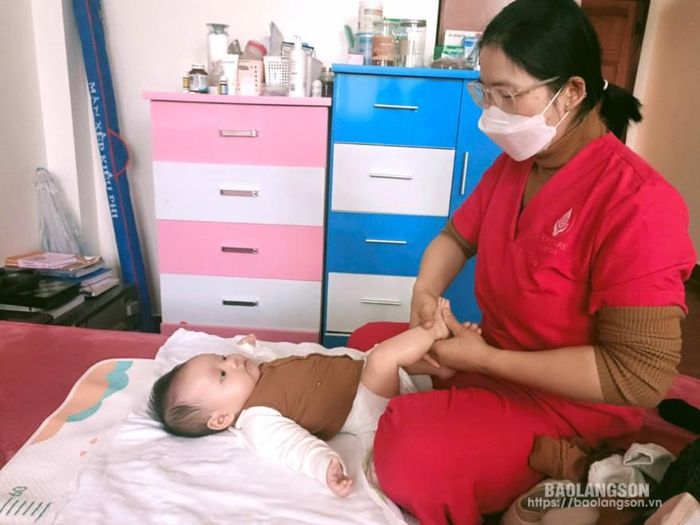 Nhân viên Trung tâm chăm sóc mẹ và bé Baby Care Lạng Sơn đang massage làm ấm cơ thể cho bé trước khi tắm tại nhà