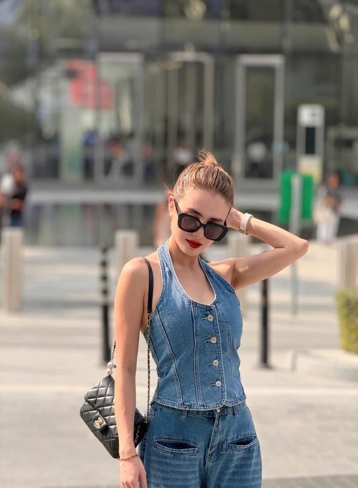 Bản phối hợp giữa chất liệu da và jeans tiếp tục được em gái Công Vinh lăng xê khi xuống phố. Người đẹp khoe vai trần nuột nà cùng chiếc túi da Chanel Classic Flap Bag đính khóa kim loại ánh vàng. Lựa chọn tông đen cổ điển giúp Lê Khánh Chi dễ dàng phối đồ, phù hợp với nhiều phong cách thời trang khác nhau. Theo tìm hiểu, mẫu túi này được ra mắt tín đồ mộ điệu với giá từ 8.000 - 12.000 USD (200 - 300 triệu đồng).