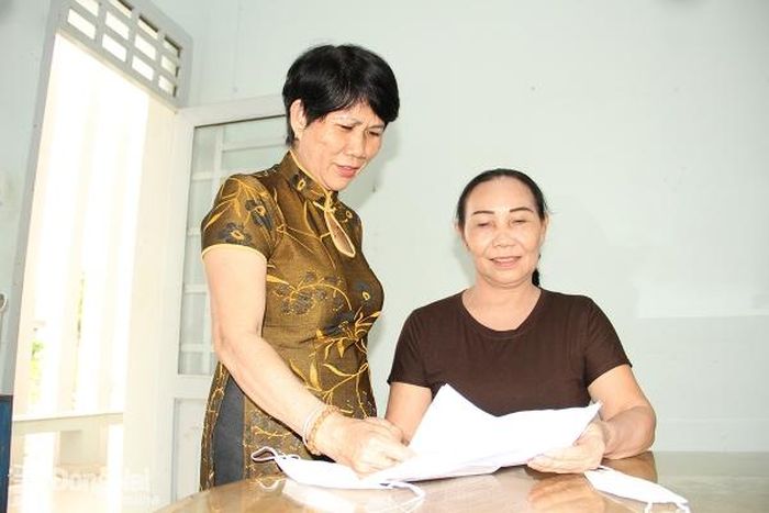 Bà Lầu Tài Múi (đứng), người có uy tín trong đồng bào dân tộc Hoa ở xã Phú Bình (huyện Tân Phú), trao đổi cùng người dân. Ảnh: S.Thao