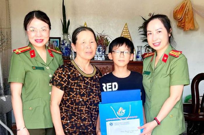 Thượng tá Nguyễn Thị Lan Hương - Chủ tịch Hội Phụ nữ Công an TP Hải Phòng (ngoài cùng, bên phải) tặng quà em Hoàng Phúc tại xã Hùng Thắng, huyện Tiên Lãng.