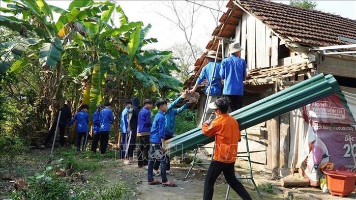 Đội hình tình nguyện hỗ trợ người dân di dời, tháo dỡ nhà cửa. Ảnh: TTXVN phát