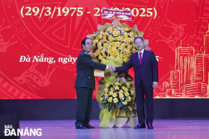 Bí thư Thành ủy Nguyễn Văn Quảng (bên phải) tặng hoa chúc mừng Ban liên lạc Mặt trận 44 Quảng Đà. Ảnh: KHÁNH NGÂN