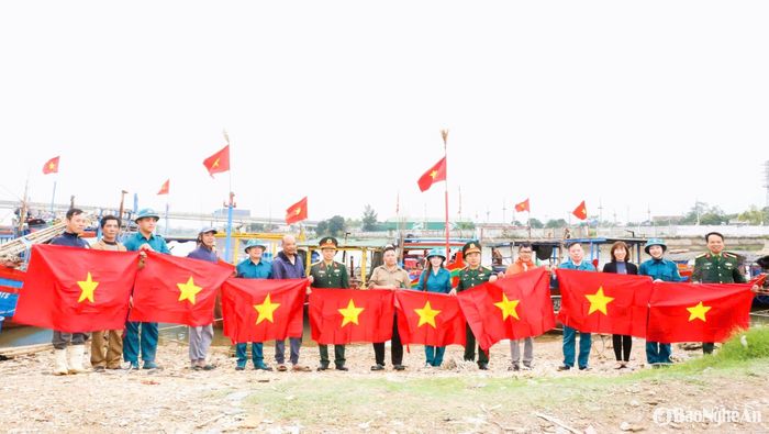 Ban Chỉ huy Quân sự thành phố Vinh trao cờ Tổ quốc cho các ngư dân tại địa bàn phường Nghi Hải, thành phố Vinh. Ảnh: Thanh Quỳnh