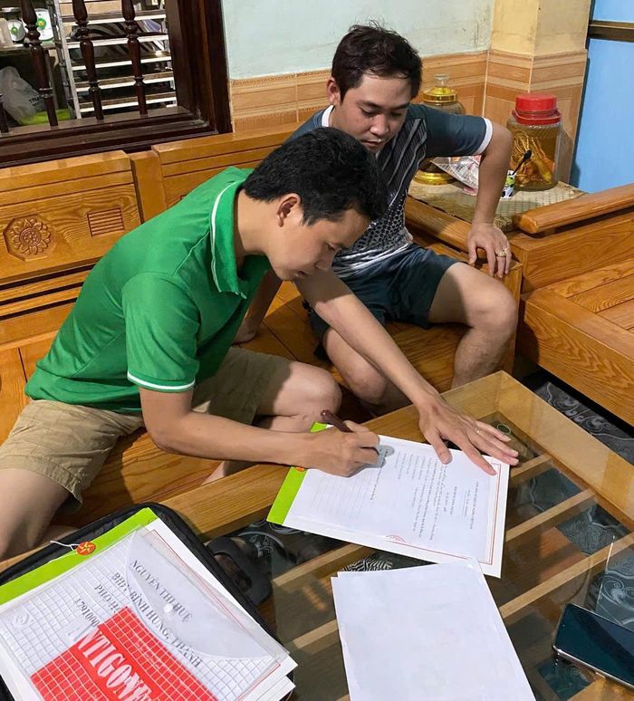 Ông Thống (trái) mang hợp đồng đến tận nhà chị Trang để chồng chị ký. Góc trái ảnh hồ sơ thấy rõ tên Nguyễn Thị Huệ và số tài khoản ngân hàng mà ông Thống cầm đến để lao động chuyển tiền. Tuy nhiên, hiện nay ông Thống lại cho biết không biết đến cái tên này. Ảnh: NDCC