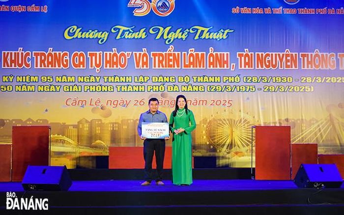 Đại diện Thư viện Khoa học tổng hợp Đà Nẵng trao bảng tượng trưng tủ sách cộng đồng cho Trung tâm Văn hóa, thông tin và thể thao quận. Ảnh: ĐOÀN HẠO LƯƠNG