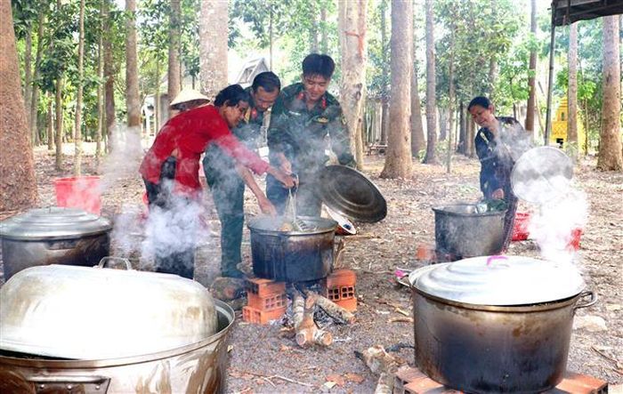 Các lực lượng tham gia Tết quân dân tại xã Đông Thành, thị xã Bình Minh cùng người dân nấu bánh tét. Ảnh: Lê Thúy Hằng – TTXVN
