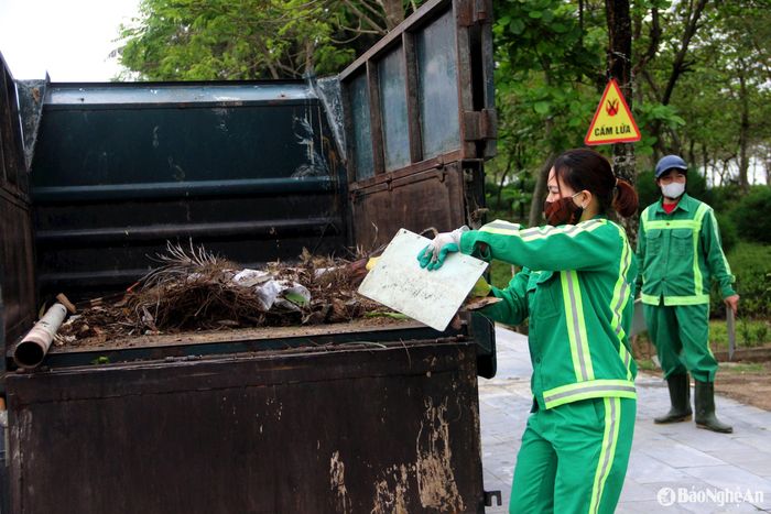 Các công nhân vệ sinh môi trường thu gom rác, vận chuyển rác thải tại biển Cửa Lò. Ảnh: Quang An