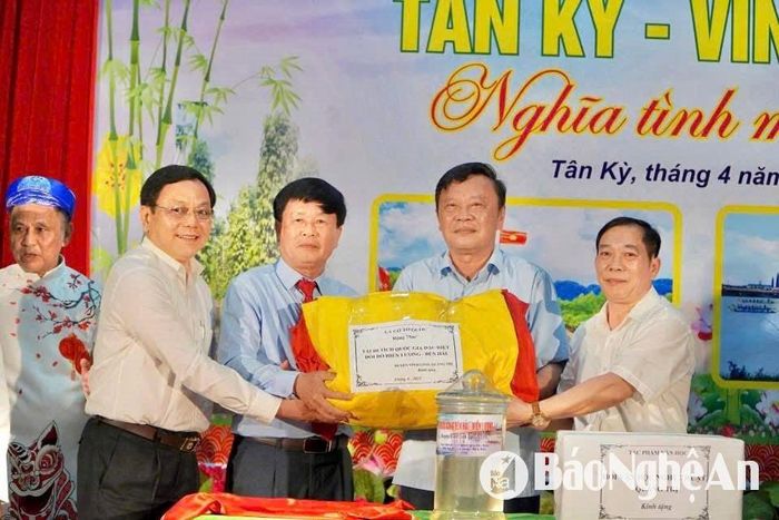 Lãnh đạo huyện Vĩnh Linh trao đại kỳ 75m² từng bay trên kỳ đài Hiền Lương – một biểu tượng của hòa hợp dân tộc cho huyện Tân Kỳ. Ảnh: CSCC