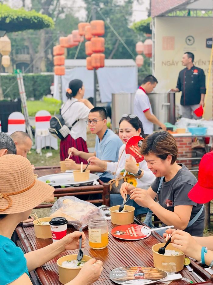 Thực khách trang bị quạt cầm tay, ô, nón để tránh nắng nóng khi thưởng thức phở ngoài trời tại Festival Phở 2025 sáng 19/4. Ảnh: Quỳnh Trang.