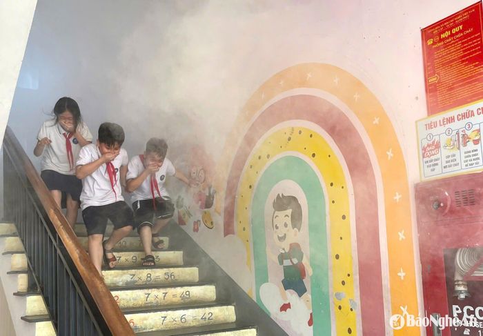Các em học sinh thực hành kỹ năng thoát nạn trong môi trường khói, khí độc. Ảnh: Chu Minh