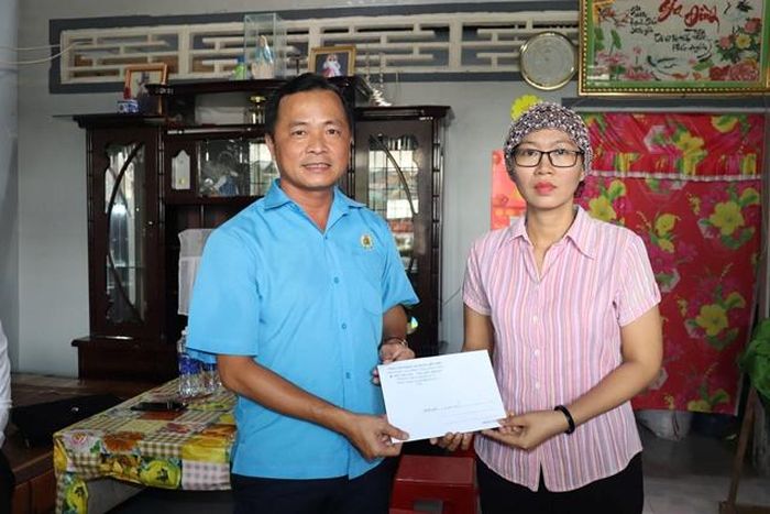 Đồng chí Nguyễn Thanh Tuấn - Phó Chủ tịch Liên đoàn Lao động tỉnh (bên trái) tặng quà hỗ trợ đoàn viên Huỳnh Thị Trang thuộc Công đoàn cơ sở Công ty TNHH Tỷ Thạc