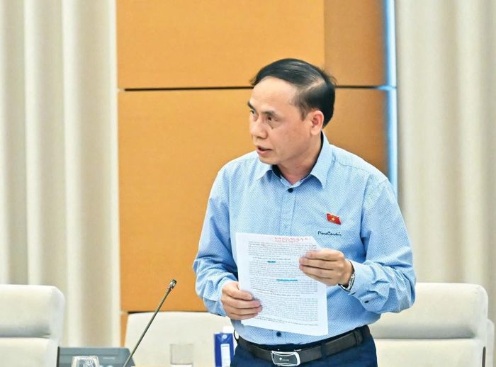  Phó Chủ nhiệm Ủy ban Pháp luật và Tư pháp Hoàng Văn Liên trình bày Báo cáo thẩm tra dự thảo Nghị quyết. Ảnh: Quang Khánh 
