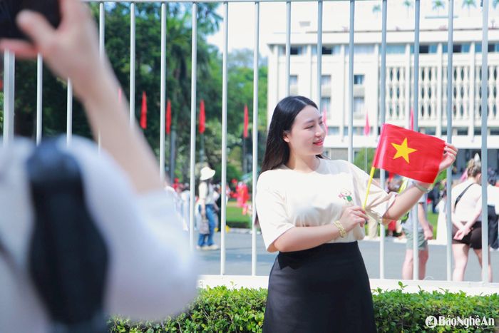 Nhiều người dân cầm cờ Tổ quốc, lưu giữ lại những hình ảnh đẹp để chia sẻ lên mạng xã hội. Ảnh: Ngân Hạnh