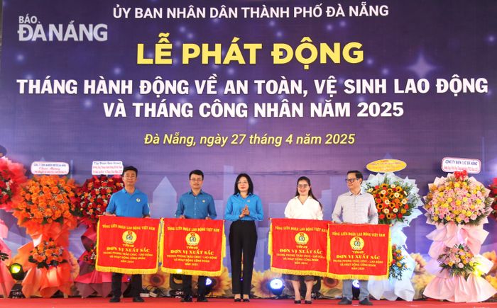 Chủ tịch Liên đoàn Lao động thành phố Phan Thị Thúy Linh (giữa) trao cờ thi đua của Chủ tịch Tổng Liên đoàn Lao động Việt Nam cho 4 đơn vị có thành tích xuất sắc trong phong trào thi đua lao động giỏi và xây dựng tổ chức Công đoàn vững mạnh năm 2024. Ảnh: L.P