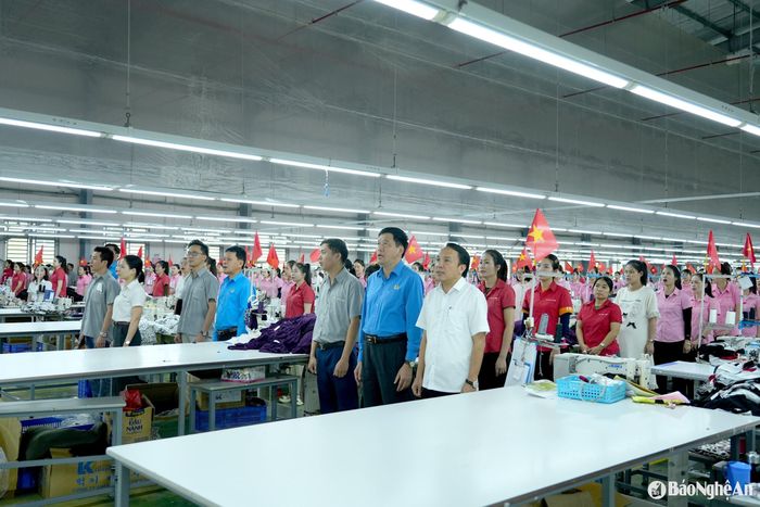 Các đồng chí Ủy viên Ban Chấp hành Đảng bộ tỉnh: Dương Đình Chỉnh - Bí thư Huyện ủy Nghi Lộc và Kha Văn Tám - Chủ tịch Liên đoàn Lao động tỉnh tham gia lễ chào cờ cùng công nhân lao động. Ảnh: Diệp Thanh