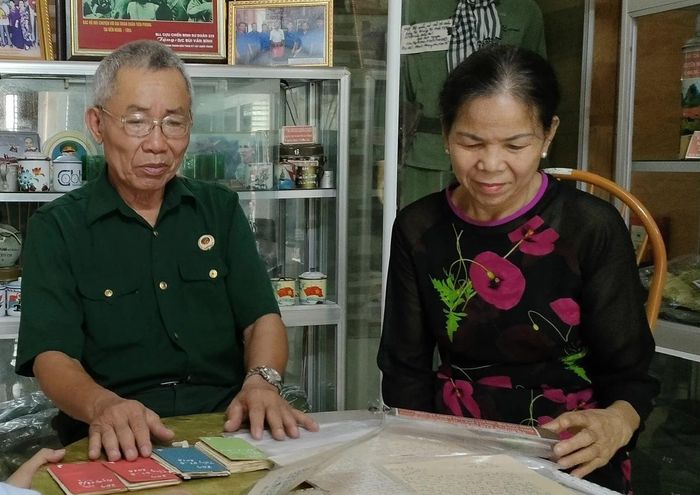 Cựu chiến binh Bùi Văn Bình cùng vợ xem lại những kỷ vật được thân nhân liệt sĩ mang đến.