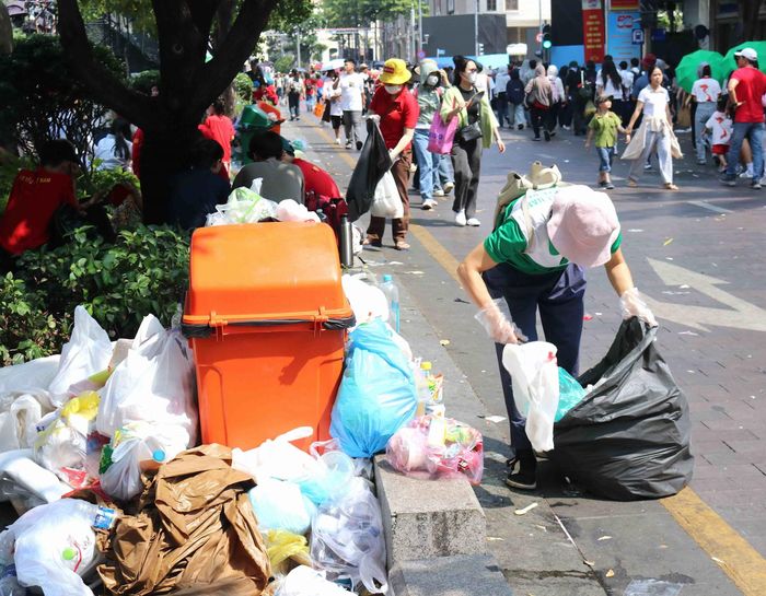 Người dân nhặt và thu gom rác tại phố đi bộ Nguyễn Huệ