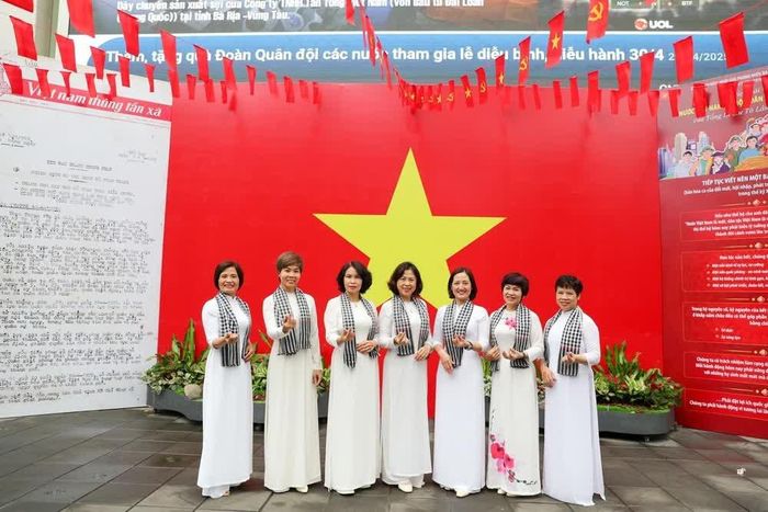 Người dân Hà Nội háo hức check-in với cờ Tổ quốc tại trụ sở Thông tấn xã Việt Nam. Ảnh: Khánh Hòa - TTXVN