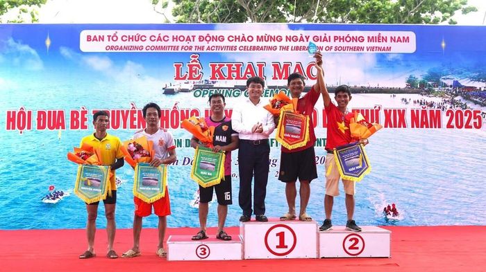 Bí thư Huyện ủy Côn Đảo, tỉnh Bà Rịa-Vũng Tàu Lê Anh Tú trao phần thưởng cho các đội bè nam đạt thành tích tại hội thi. Ảnh: Huỳnh Sơn-TTXVN