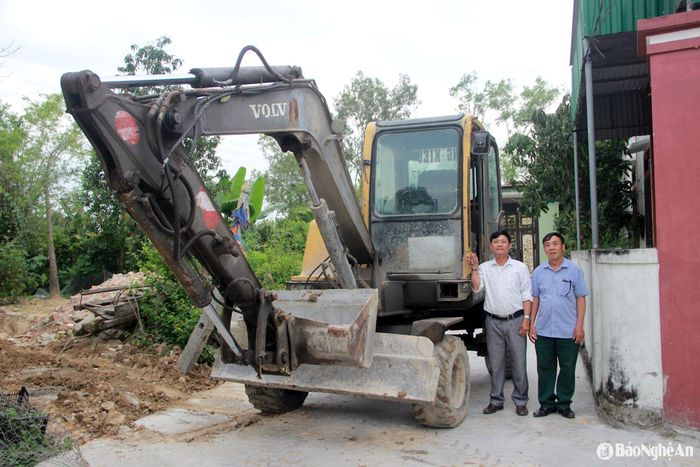 Cựu chiến binh Nguyễn Quốc Năng (bên trái) đầu tư máy móc, thi công những công trình tại địa phương. Ảnh: Quang An
