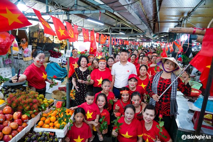 Tiểu thương rạng rỡ trong áo cờ đỏ sao vàng, đeo băng rôn "Tôi yêu Việt Nam". Ảnh: Thanh Phúc