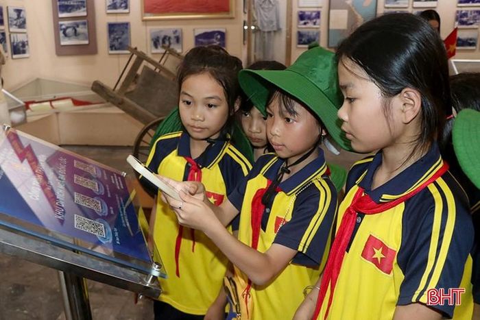  Du khách quét mã QR để nhận các thông tin về Khu di tích Ngã ba Đồng Lộc. 