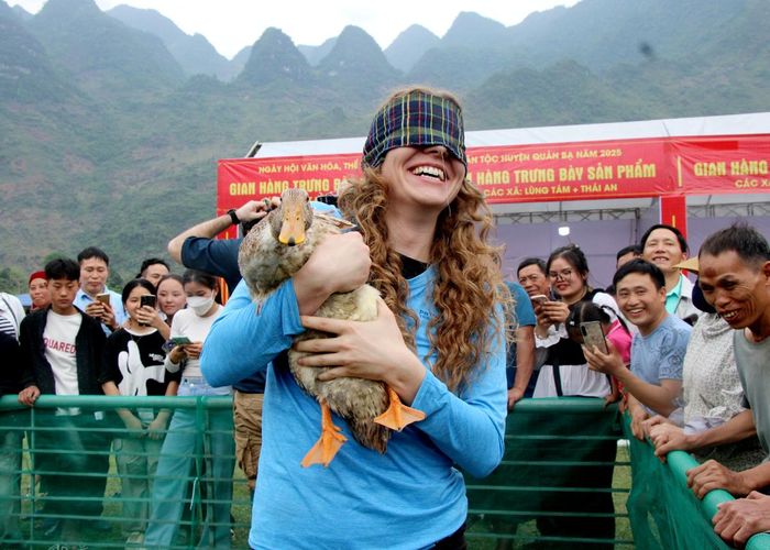 Du khách nước ngoài tham gia thử thách thi bịt mắt bắt vịt.