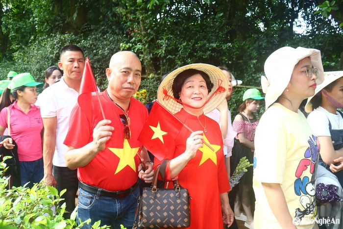 Bà Phạm Thị Thế (62 tuổi) thường trú ở quận Cầu Giấy, thủ đô Hà Nội có mặt tại Làng Sen chia sẻ: Tôi đã về thăm quê Bác nhiều lần, mỗi lần đến đây vẫn xúc động như lần đến đầu tiên. Dịp nghỉ lễ này, vợ chồng tôi lại về Kim Liên trong trang phục áo đỏ sao vàng và cờ Tổ quốc cầm tay. Ảnh: Huy Thư