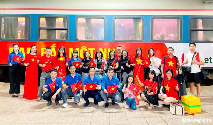 Hành khách trên chuyến tàu Thống Nhất chụp hình lưu niệm với người dân Nghệ An. Ảnh: Quang An