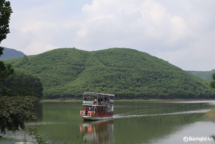 Thuyền chở du khách lướt trên mặt hồ Vệ Vừng phẳng lặng khám phá vẻ đẹp hoang sơ. Ảnh: Văn Trường