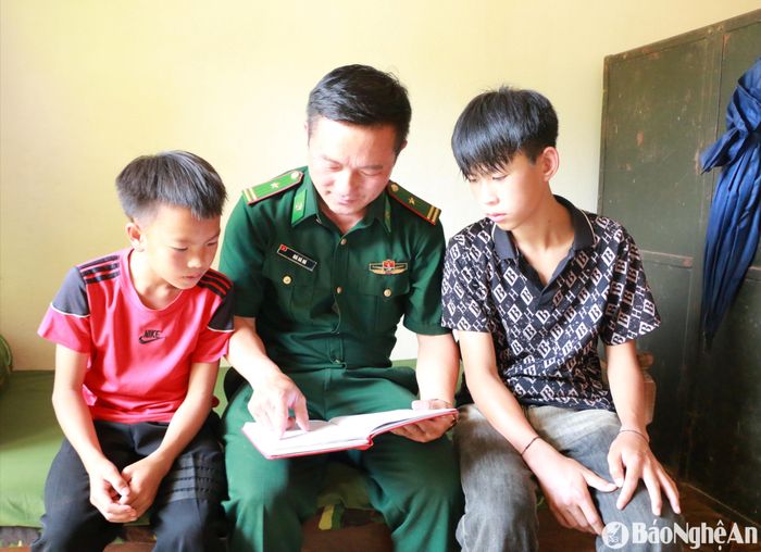 Thiếu tá Già Bá Ná bên các con nuôi biên phòng là cháu Vừ Bá Lầu và Vi Dương Cầm. Ảnh: Thanh Phúc