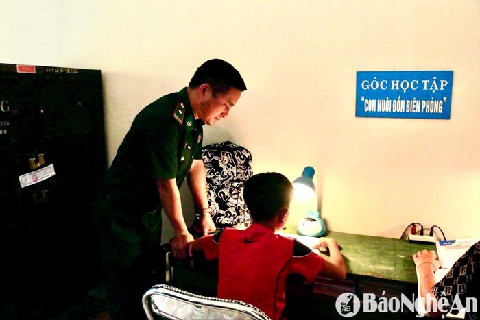 Cán bộ Đồn Biên phòng Na Ngoi hướng dẫn con nuôi học bài. Ảnh: Khánh Ly