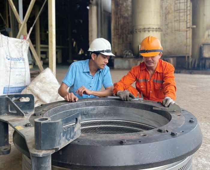 Anh Nguyên (trái) đang nghiên cứu cải tiến khuôn ép máy nén viên tại Nhà máy viên năng lượng Cam Lộ - Ảnh: K.S