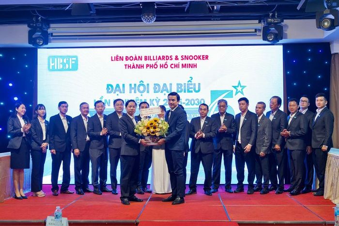 Chủ tịch HBSF Nguyễn Văn Trí (trái) nhận hoa chúc mừng từ ông Nguyễn Nam Nhân - Phó Giám đốc Sở Văn hóa và Thể thao TP.HCM. Ảnh: LP