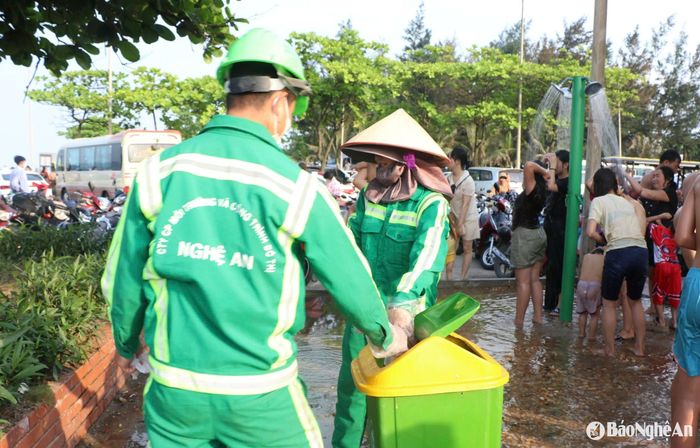 Công nhân vệ sinh môi trường thu gom rác tại khu vực tắm tráng. Ảnh: Nguyễn Hải