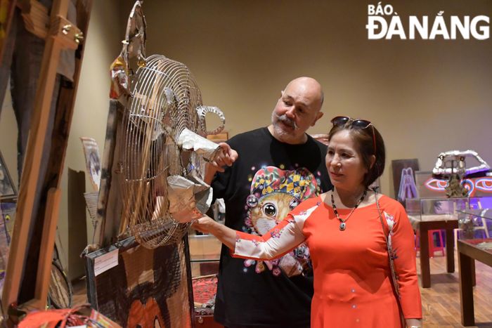 Họa sĩ David nhiệt tình chia sẻ với khách tham quan về chất liệu cũng như kỹ thuật tạo nên tác phẩm.