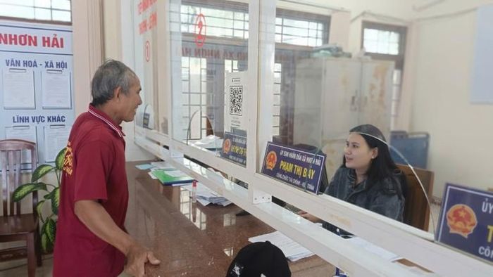  Nhân viên xã Nhơn Hải (thành phố Quy Nhơn) hướng dẫn người dân thủ tục hành chính.