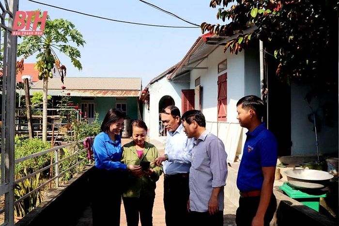 Tổ công nghệ số cộng đồng xã Định Bình đến nhà hộ dân hướng, hướng dẫn người dân cài đặt tài khoản định danh điện tử và tra cứu thông tin.
