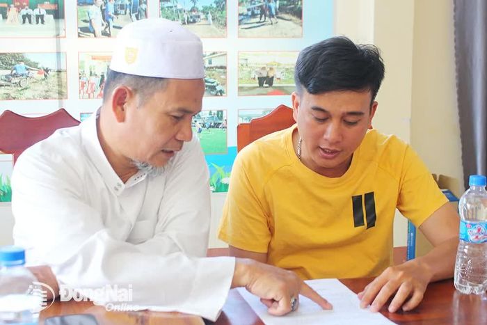 Người có uy tín, giáo cả làng Chăm ấp 4, xã Xuân Hưng (huyện Xuân Lộc) Ab Do Ha Mit hướng dẫn thanh niên dân tộc Kinh về thủ tục kết hôn với phụ nữ Chăm.