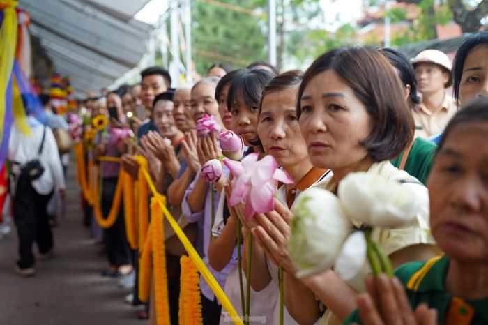 Phật tử trong trang phục chỉnh tề, xếp hàng trang nghiêm trước cổng chùa.